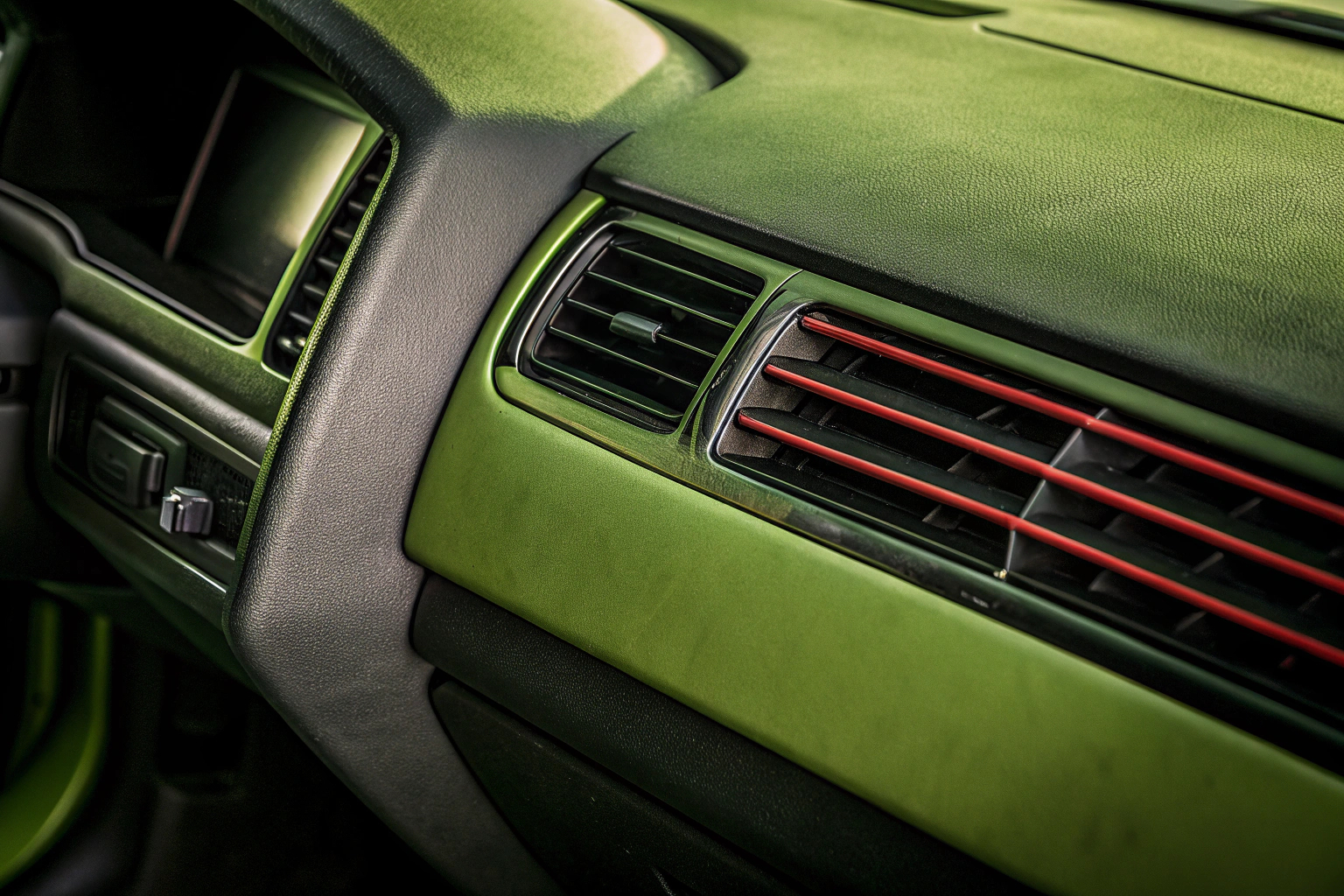 Detailaufnahme eines Autos mit dekorativen Lüftungsschlitzen in auffälligen Farben, die den Innenraum aufwerten. Dekorative Lüftungsschlitze im Auto