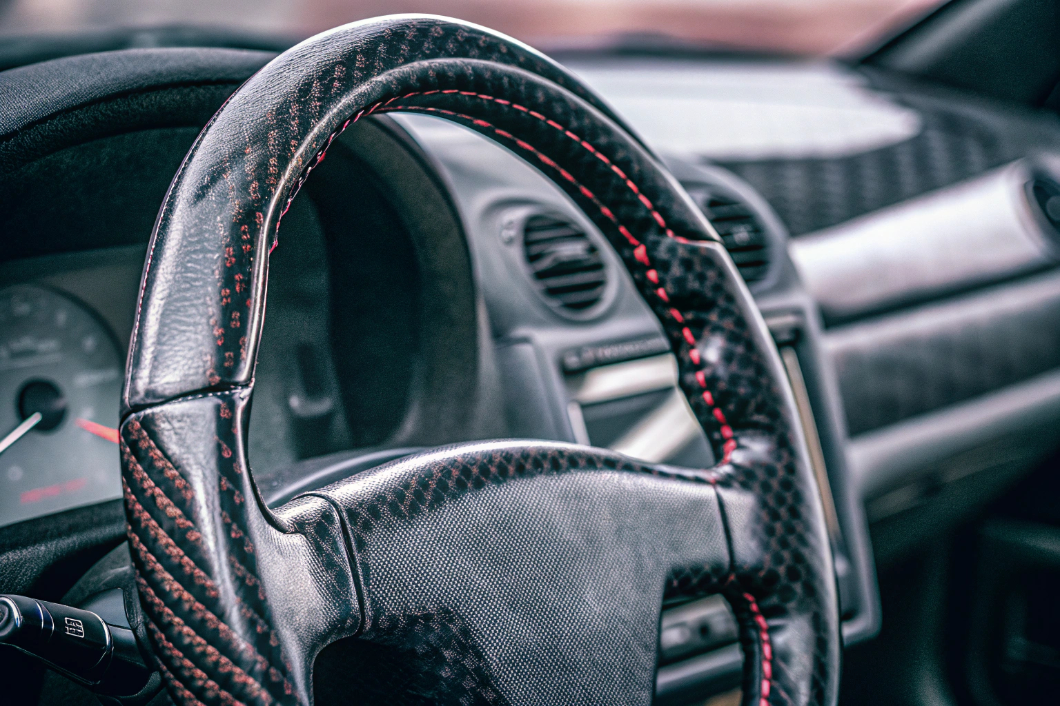 Detailaufnahme eines sportlichen Lenkrads in einem getunten Auto. Sportliches Lenkrad im Auto
