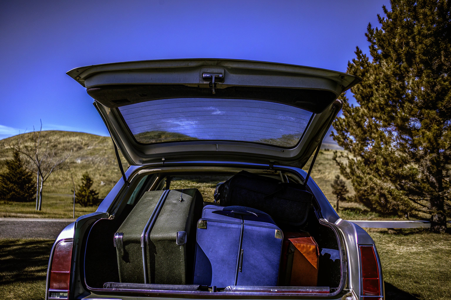 Ein Auto beladen mit Koffern und Taschen, bereit für einen Roadtrip. Auto beladen für Roadtrip