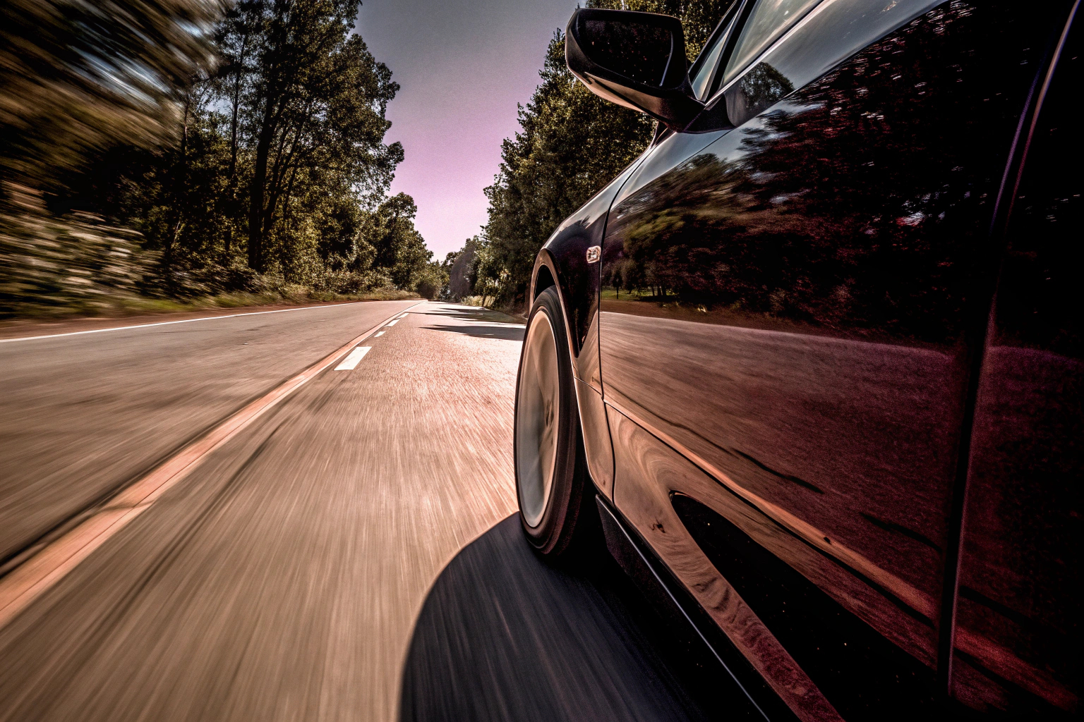 Ein Auto mit Sommerreifen, das auf einer trockenen Landstraße fährt. Auto mit Sommerreifen