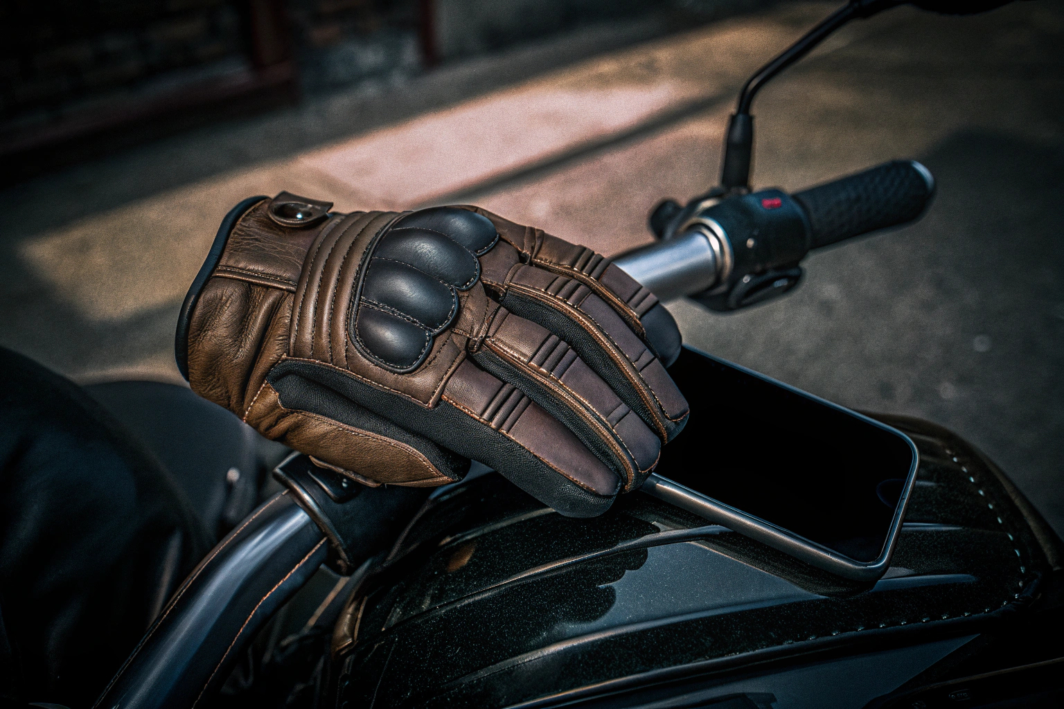 Ein Biker, der die COZOME Motorradhandschuhe trägt und ein Smartphone bedient. COZOME Motorradhandschuhe mit Touchscreen-Funktion