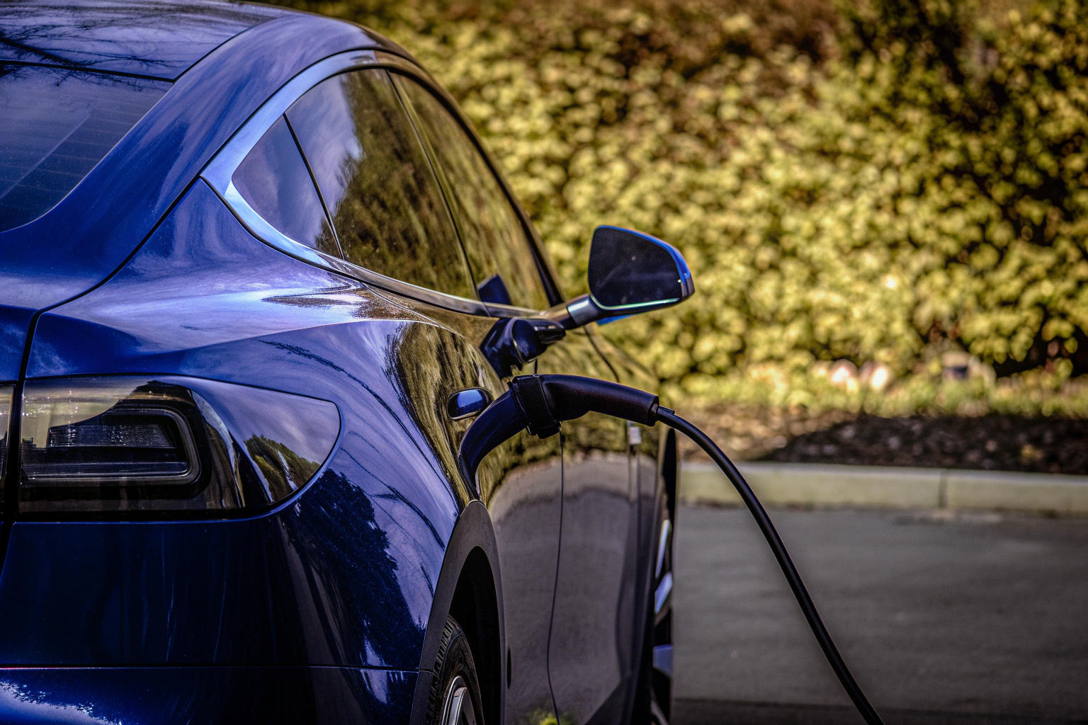 Ein Elektroauto, das an einer Ladestation mit einem hochwertigen Ladekabel angeschlossen ist. Elektroauto an Ladestation