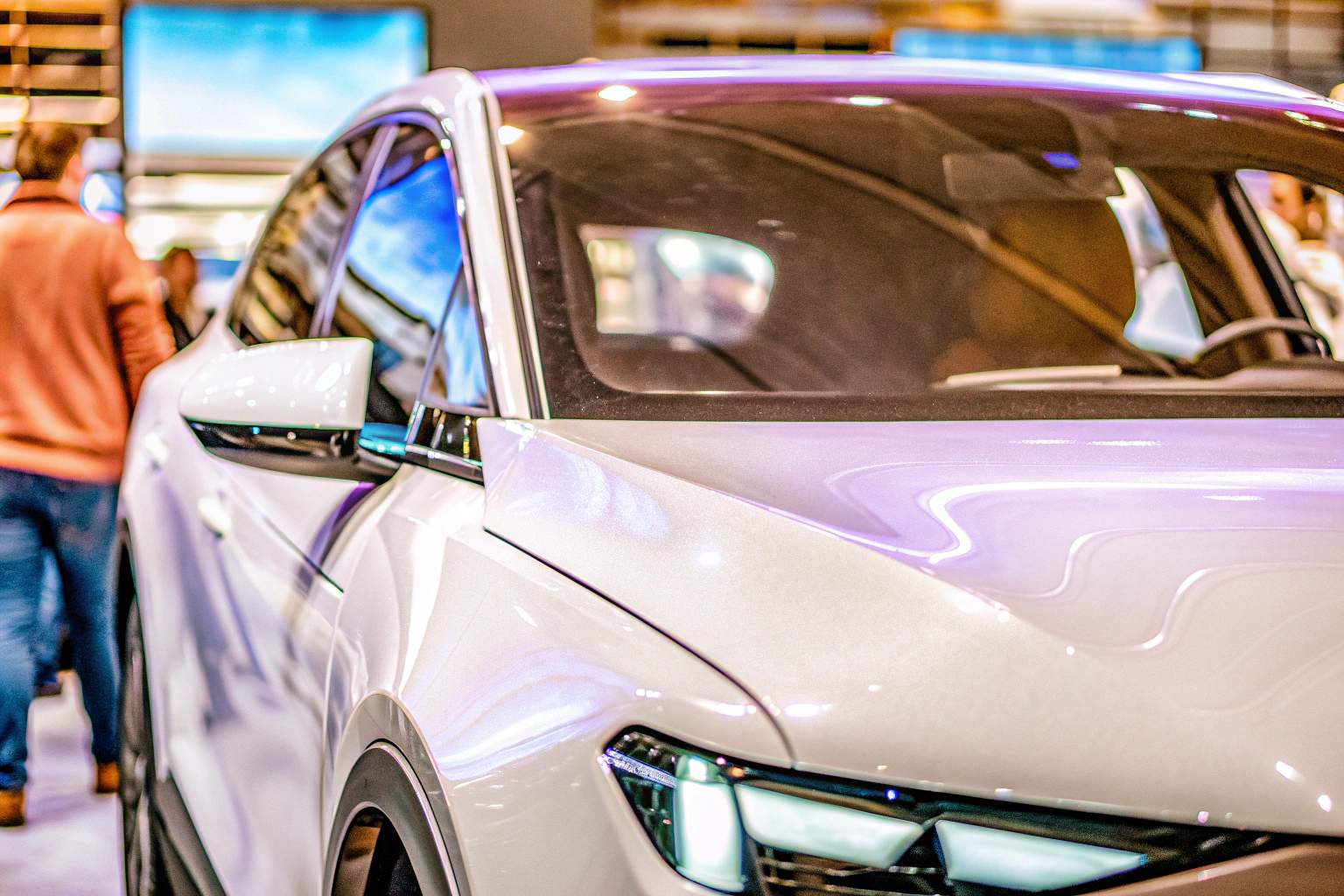 Ein futuristisches Elektroauto auf einer Messe mit Besuchern, die sich die technischen Details ansehen. Futuristisches Elektroauto