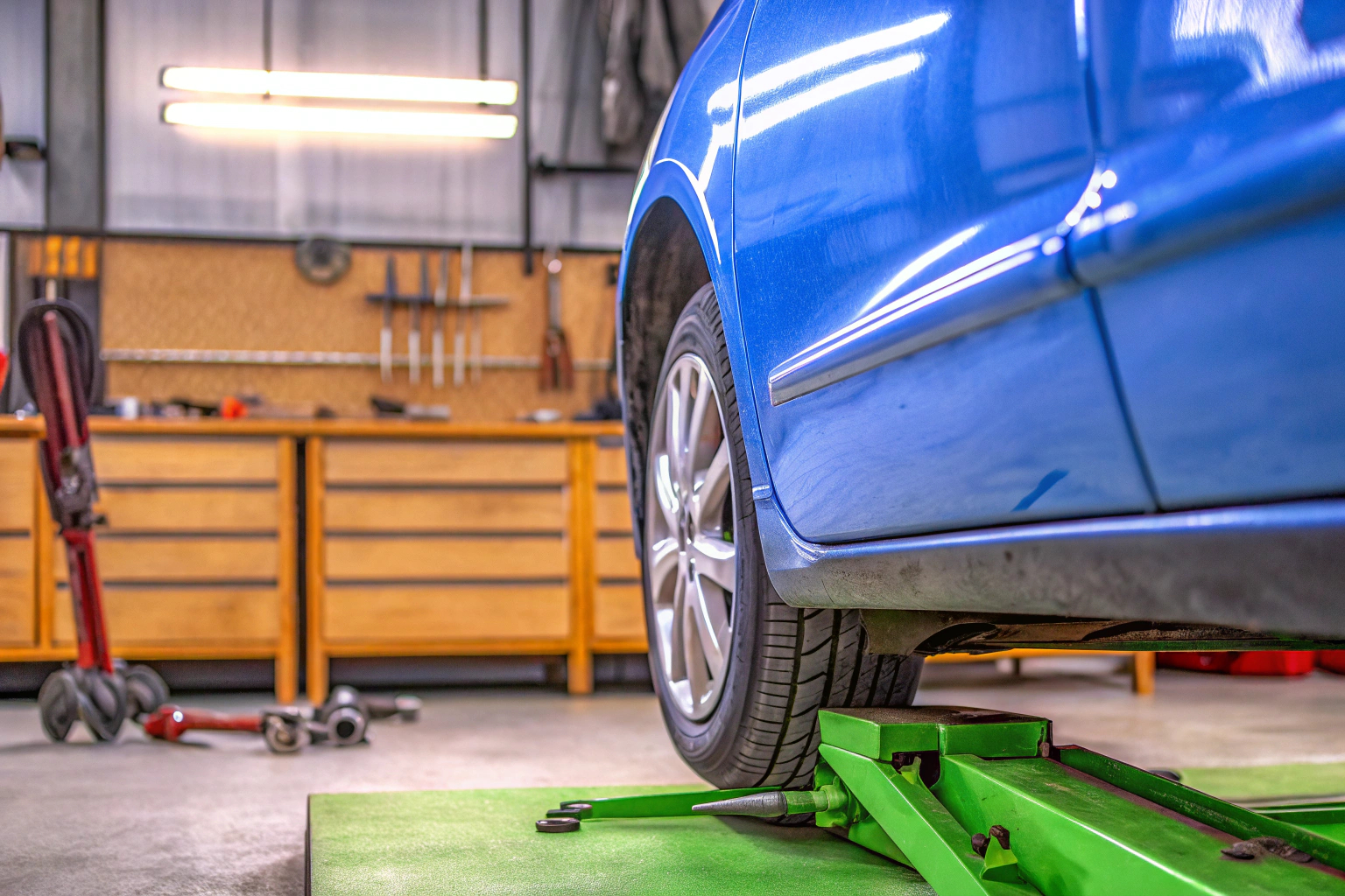 Ein hydraulischer Wagenheber hebt ein Auto für die Durchführung von Reparaturen an. Hydraulischer Wagenheber im Einsatz