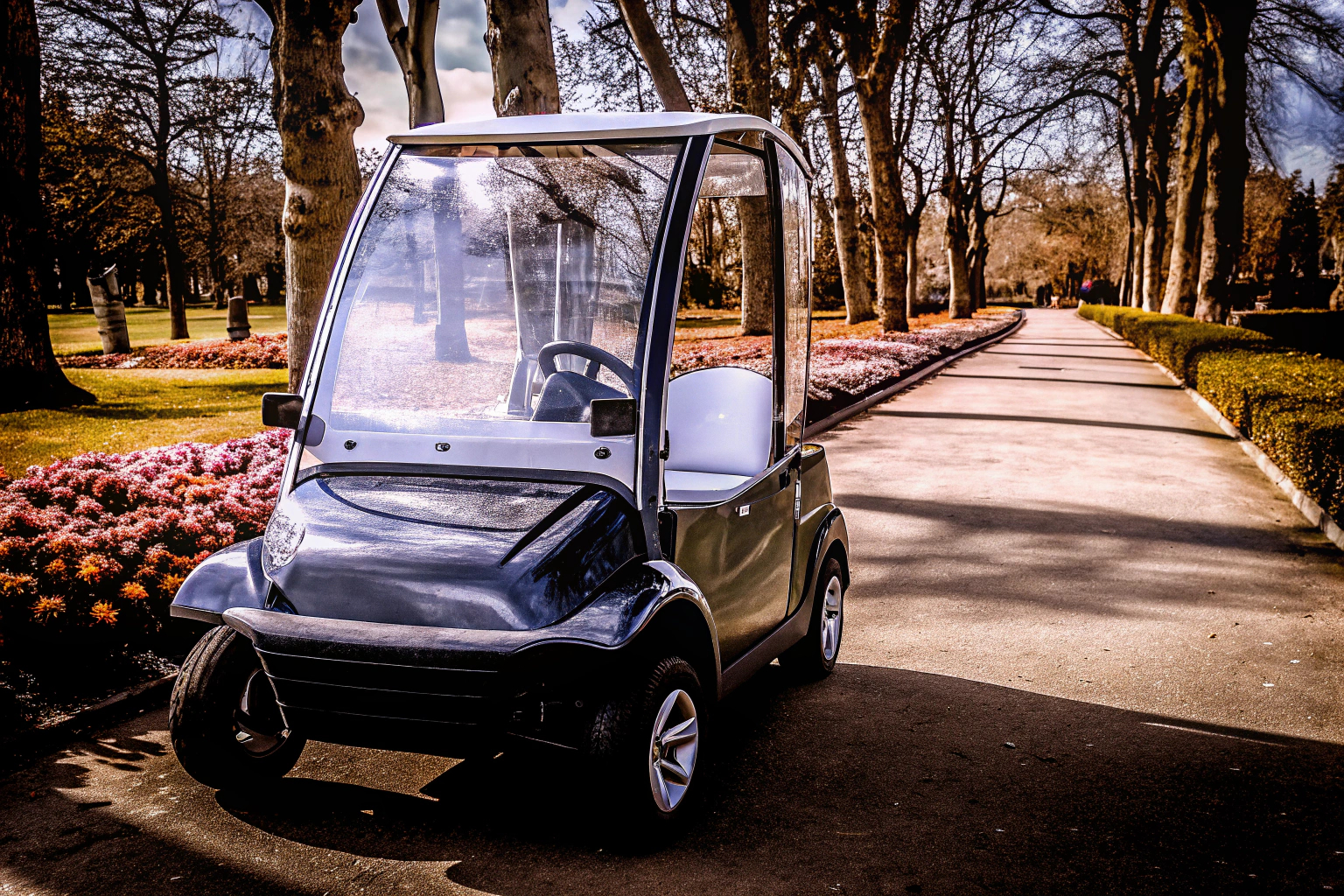 Ein Kind fährt in einem kleinen Elektroauto durch einen Park. Kind im Elektroauto