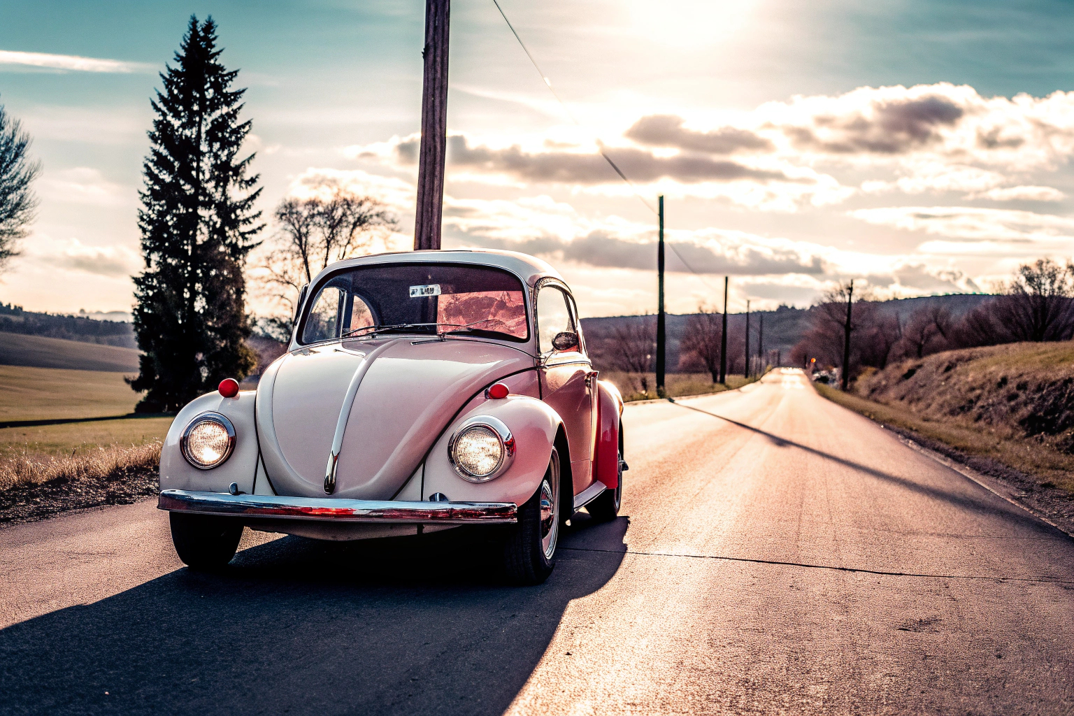 Ein klassischer Volkswagen Käfer auf einer Landstraße, der die ikonische Form und das charakteristische Design zeigt. Klassischer Volkswagen Käfer