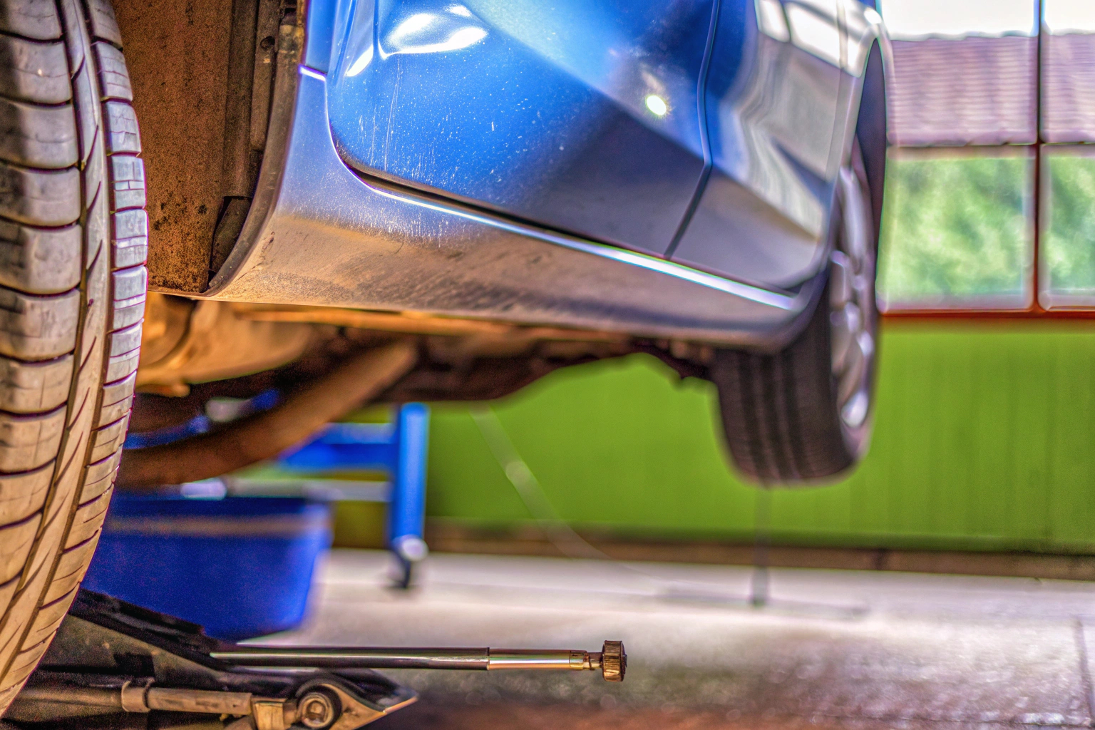 Ein Mechaniker, der eine Autoinspektion durchführt. Er überprüft den Zustand der Bremsen und der Reifen. Mechaniker bei Autoinspektion