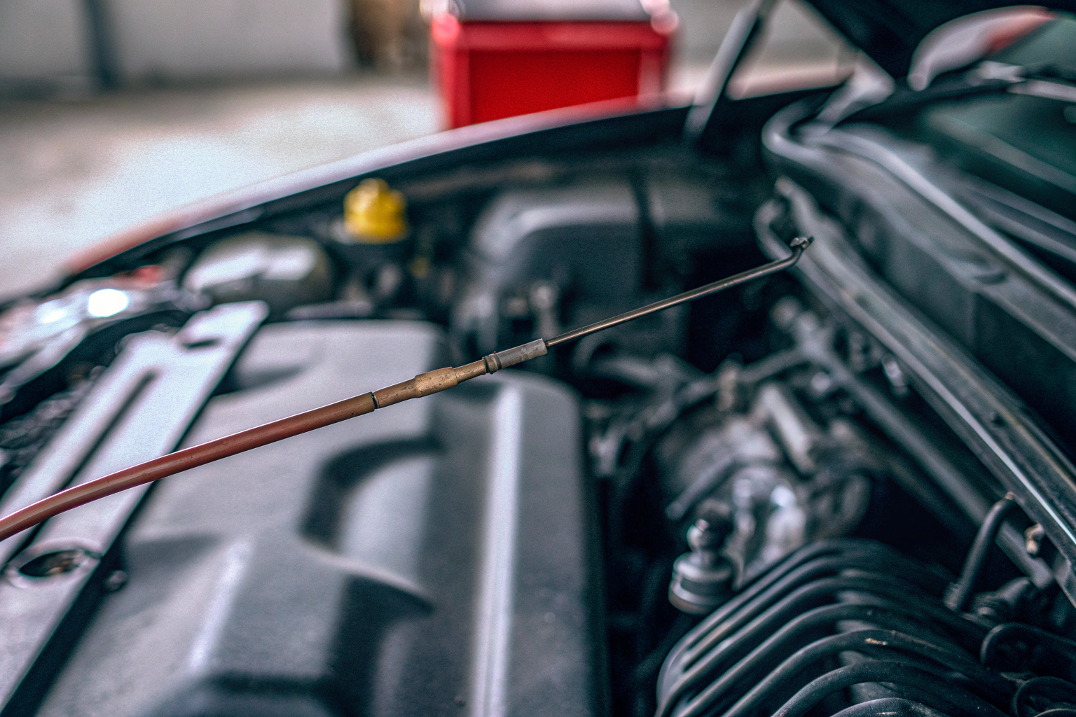 Ein Mechaniker kontrolliert den Ölstand eines Autos während einer Inspektion. Ölstandkontrolle bei Autoinspektion