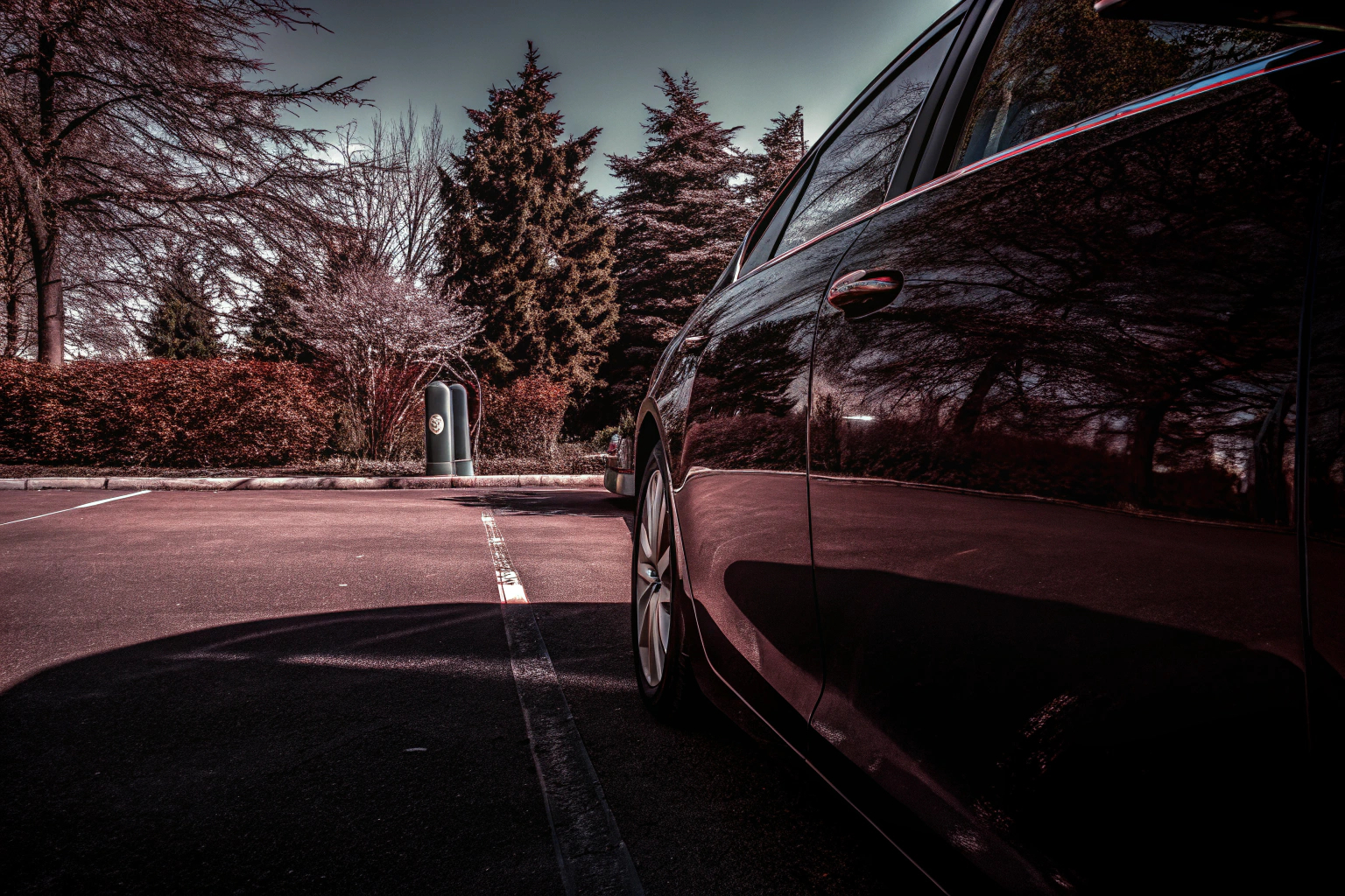 Ein moderner Hybridwagen auf einem Parkplatz mit Ladestation. Hybridfahrzeug an Ladestation