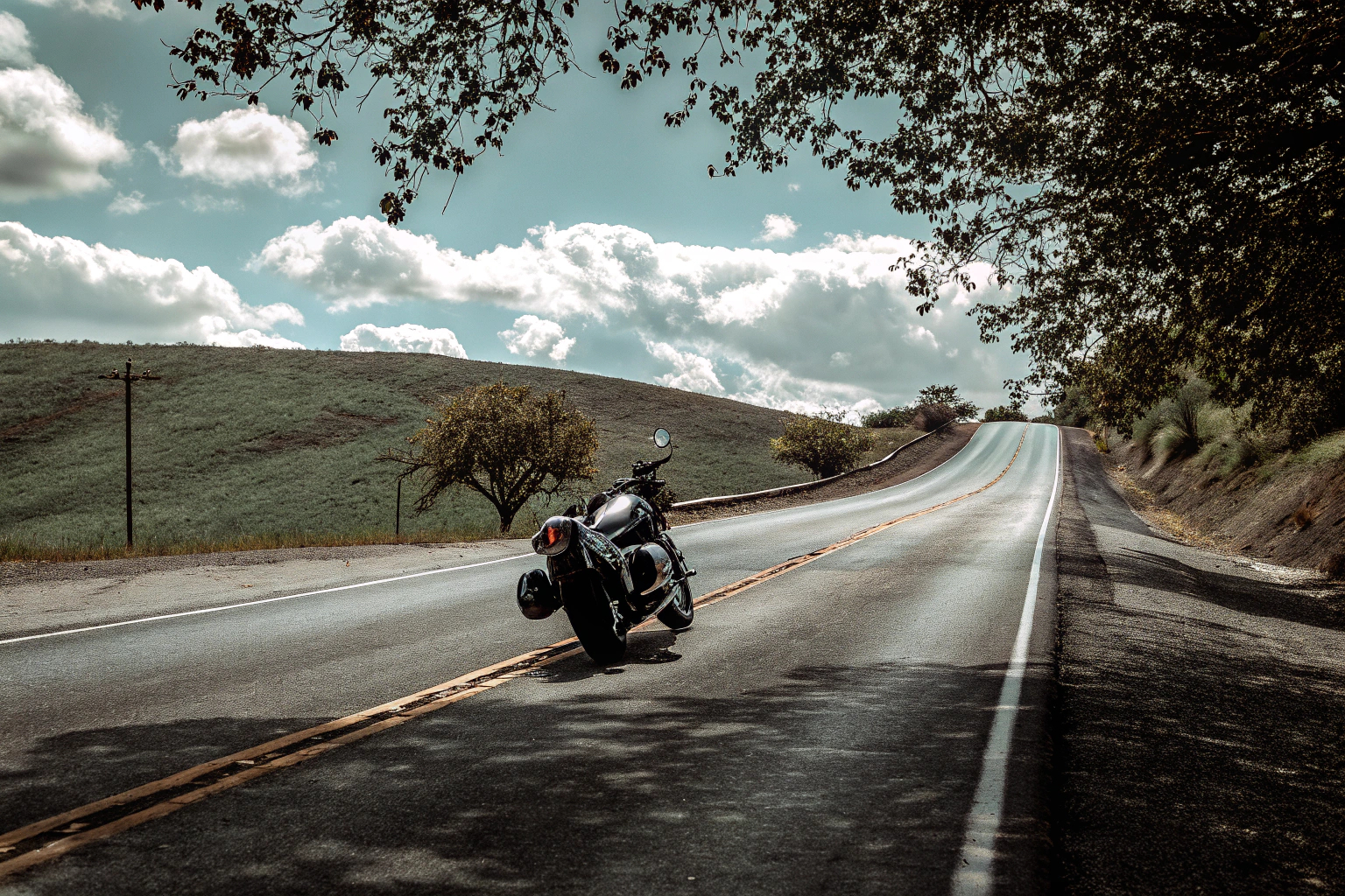 Ein Motorradfahrer, der auf einer malerischen Landstraße fährt, mit atemberaubender Landschaft im Hintergrund. Motorradfahrer auf Landstraße