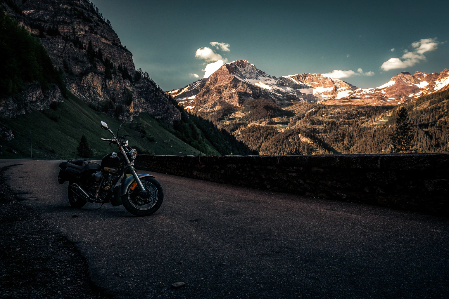 Ein Motorradfahrer genießt die Aussicht auf eine kurvenreiche Bergstraße in den deutschen Alpen. Motorradfahrer in den Alpen