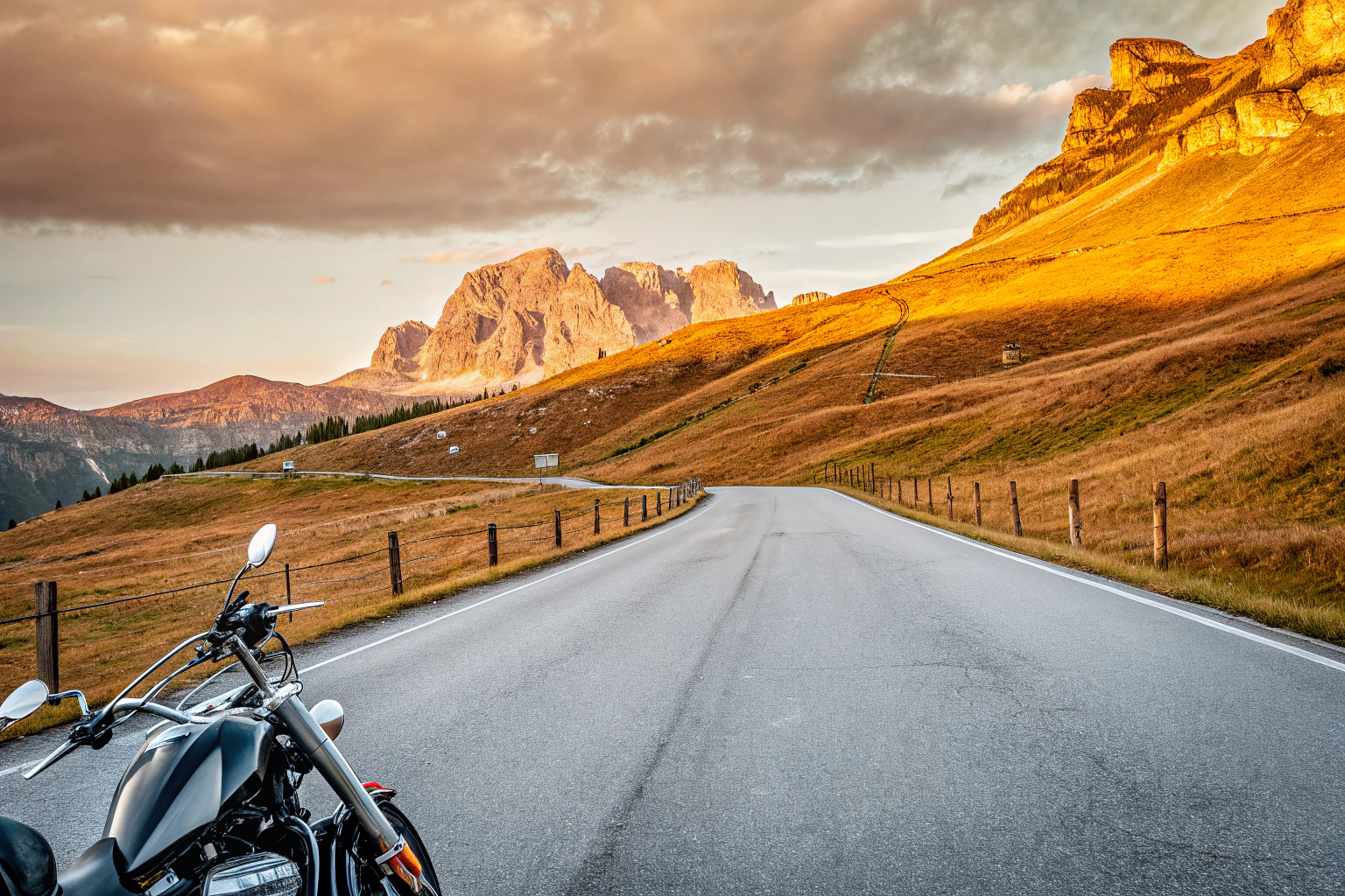 Ein Motorradfahrer genießt die Aussicht auf einer kurvenreichen Bergstraße in den Alpen. Motorradfahrer in den Alpen