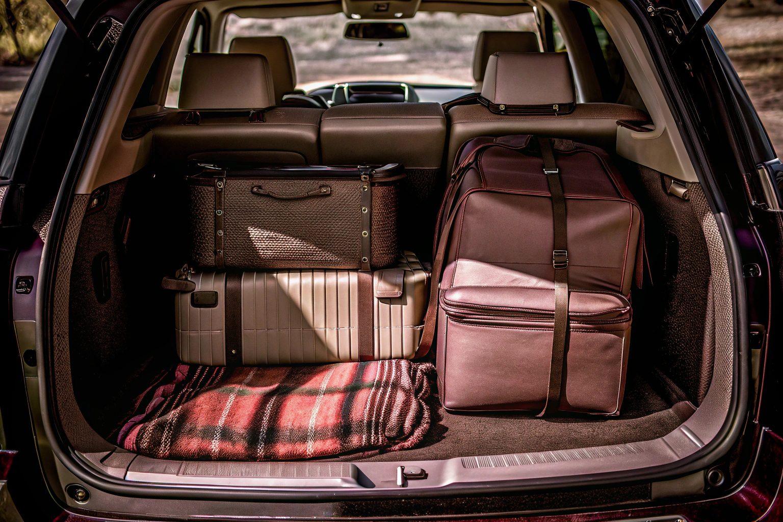 Eine Familie belädt ein Auto mit Gepäck für den Urlaub, mit Fokus auf der richtigen Gewichtsverteilung. Familie belädt Auto für den Urlaub