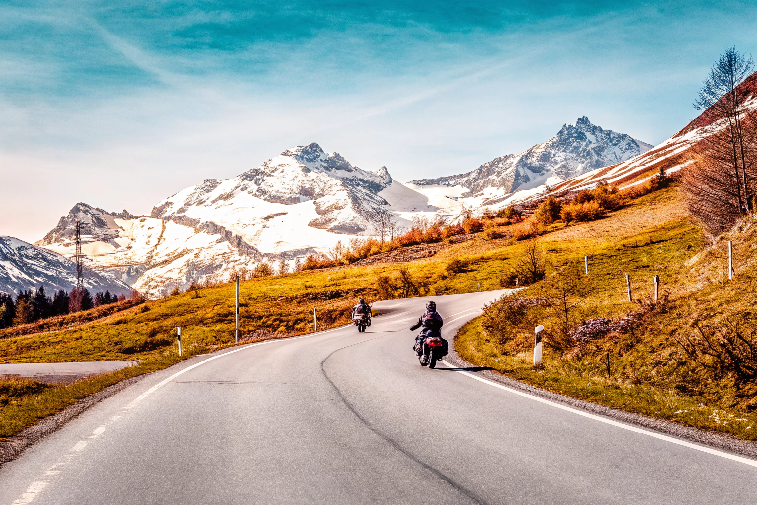 Eine malerische Straße in den Alpen, ideal für Motorradtouren. Alpen Motorradtour
