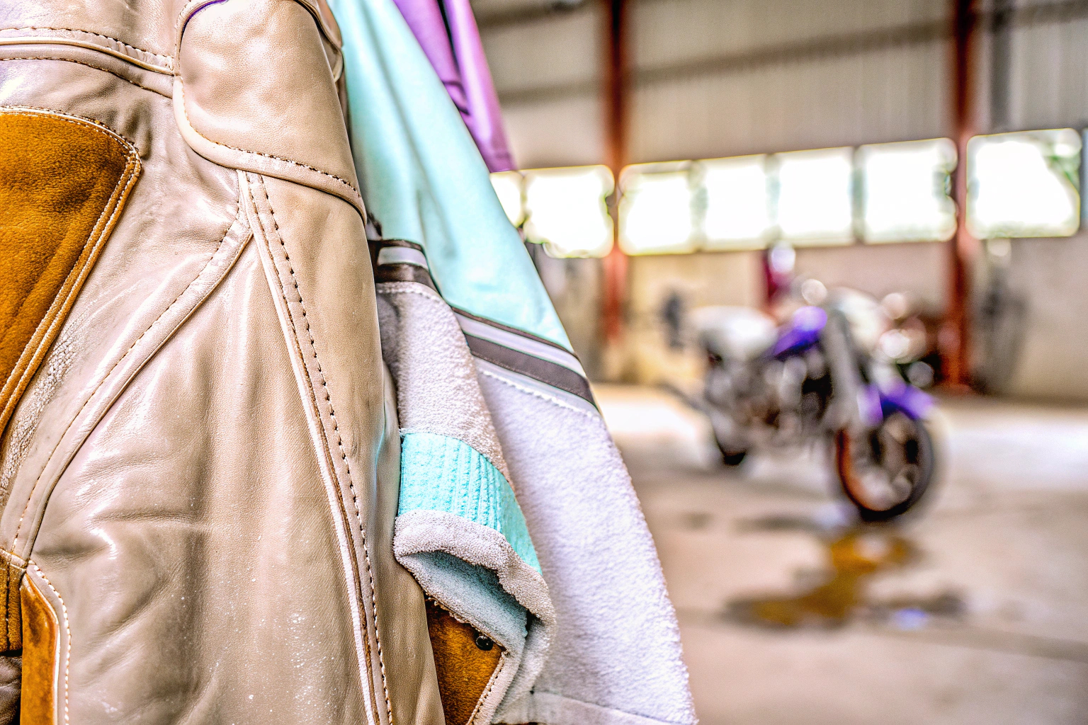 Eine Motorradjacke wird mit einem feuchten Tuch gereinigt, um Schmutz zu entfernen. Reinigung einer Motorradjacke