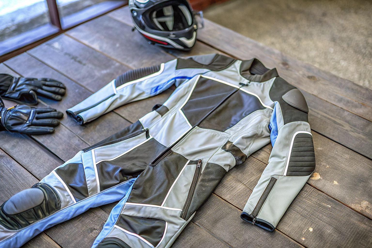 Eine Motorradkombi mit mehreren Schichten und Protektoren auf einem Tisch ausgebreitet. Motorradkombi mit Protektoren