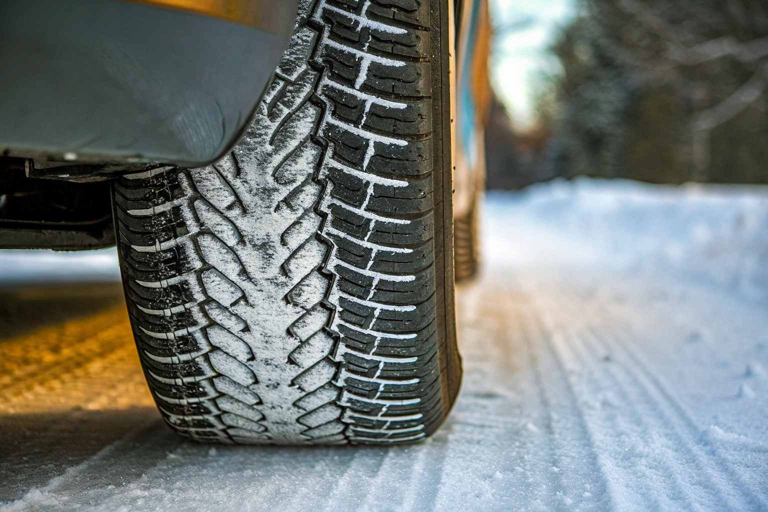 Eine Nahaufnahme von Winterreifen im Schnee, die das spezielle Profil und die Gummimischung zeigen. Winterreifen im Schnee