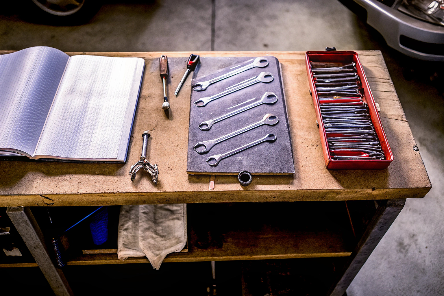 Eine Sammlung von Autoreparaturwerkzeugen, die auf einem Werkstatttisch ausgebreitet sind. Autoreparaturwerkzeuge