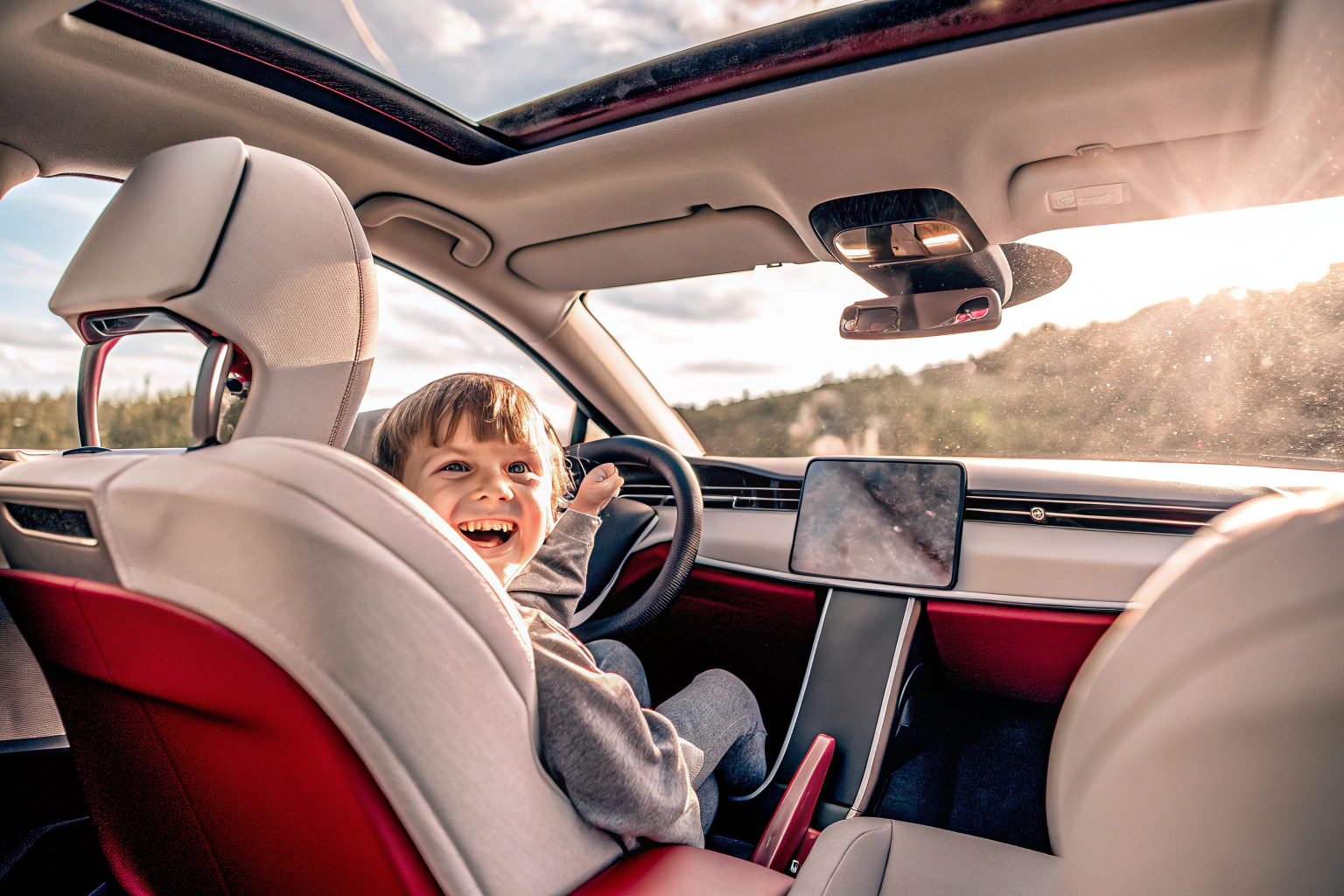 Kind in einem Elektroauto mit einem breiten Lächeln im Gesicht Kind in Elektroauto
