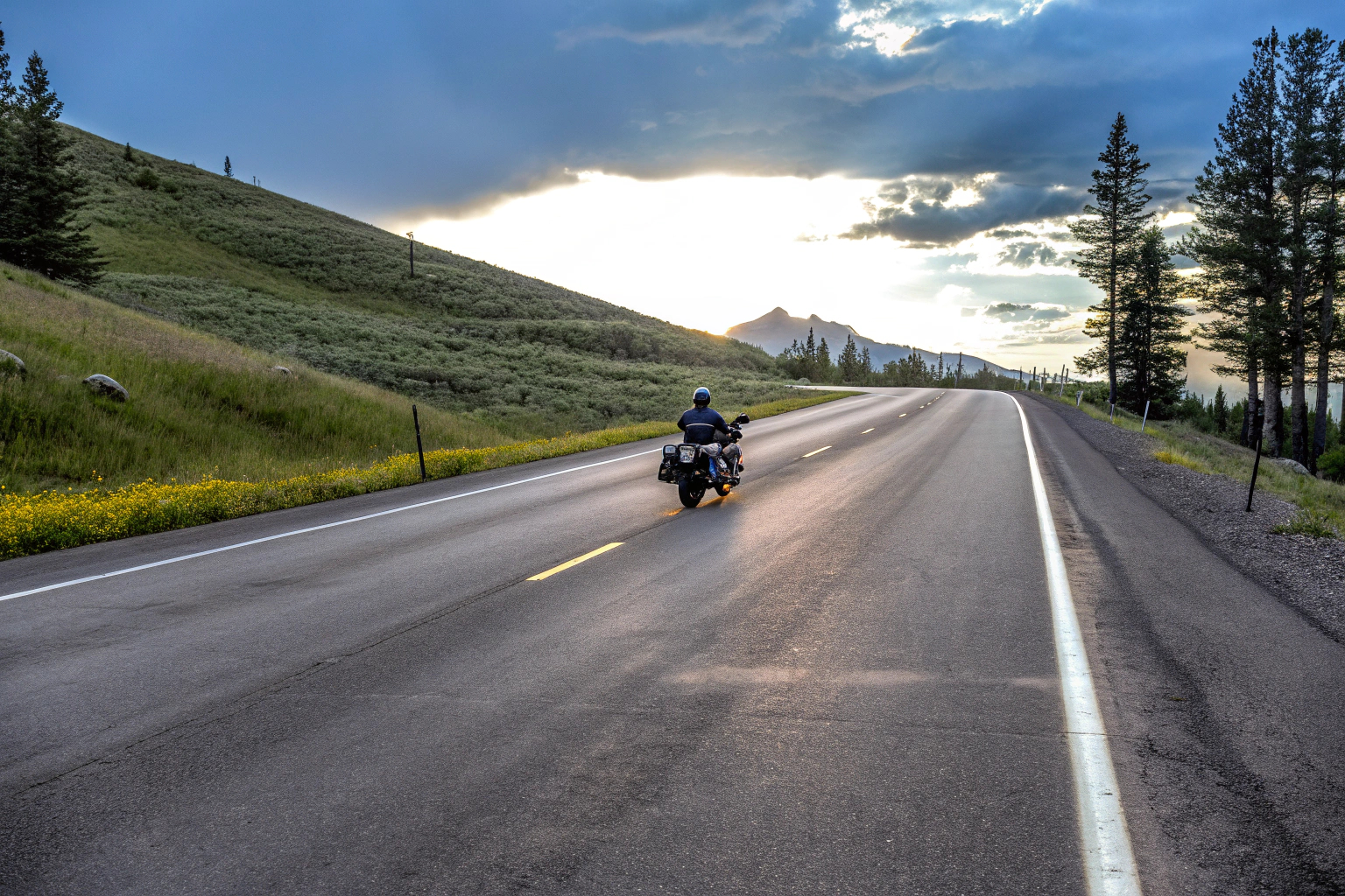 Motorradfahrer, der eine malerische Aussicht genießt, während er eine Straße entlang fährt. Motorradfahrer mit Aussicht