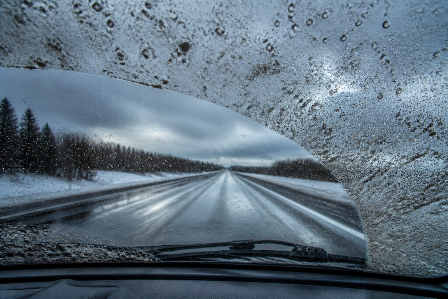 Verschmutzte Autoscheibe im Winter mit Salz und Streusalzresten