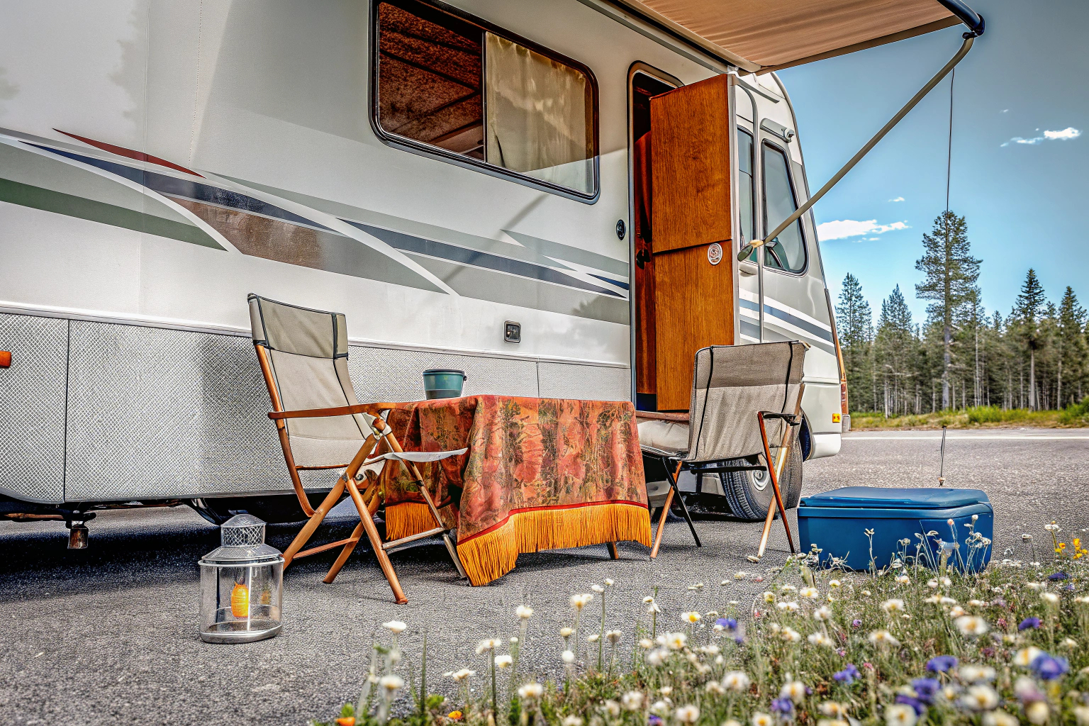 Wohnmobil auf einem Campingplatz mit geöffneter Markise und ausgestellten Campingstühlen. Wohnmobil Campingplatz